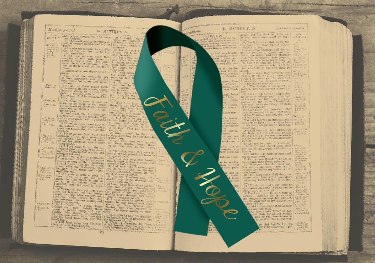 green faith and hope ribbon on top of an open bible