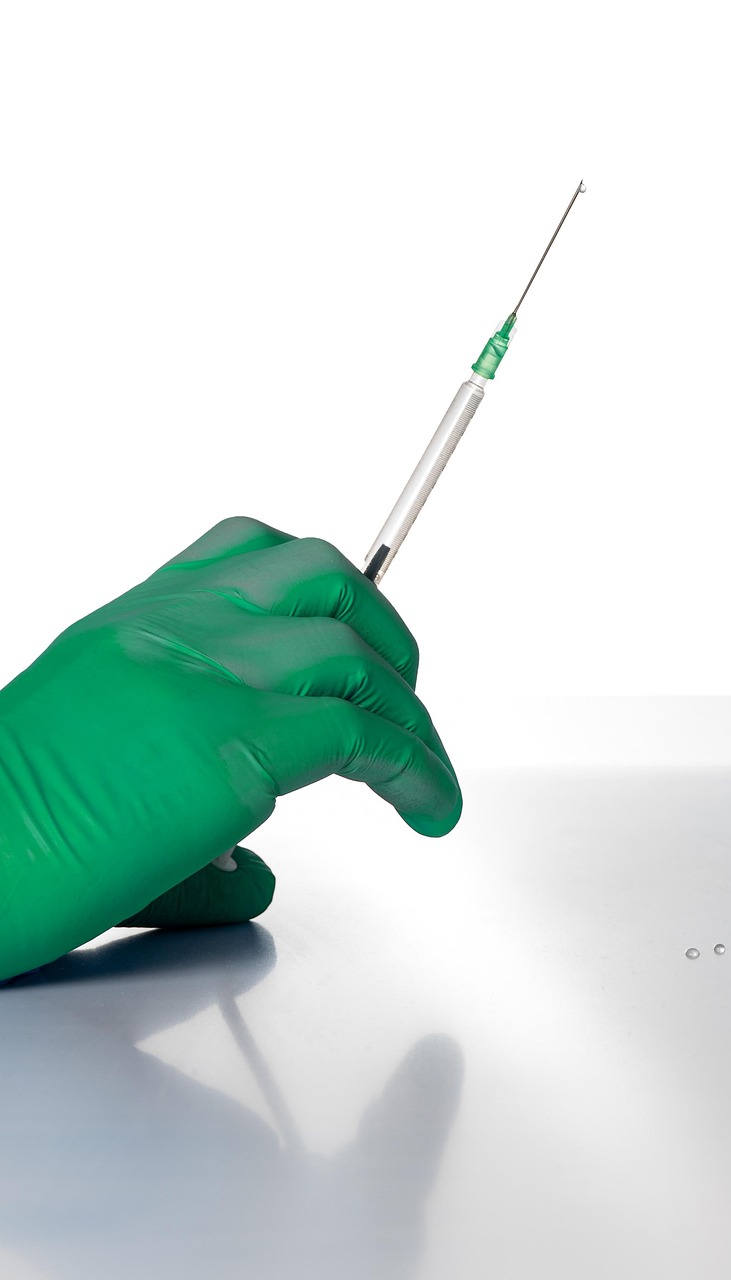 gloved hand holding a hypodermic needle