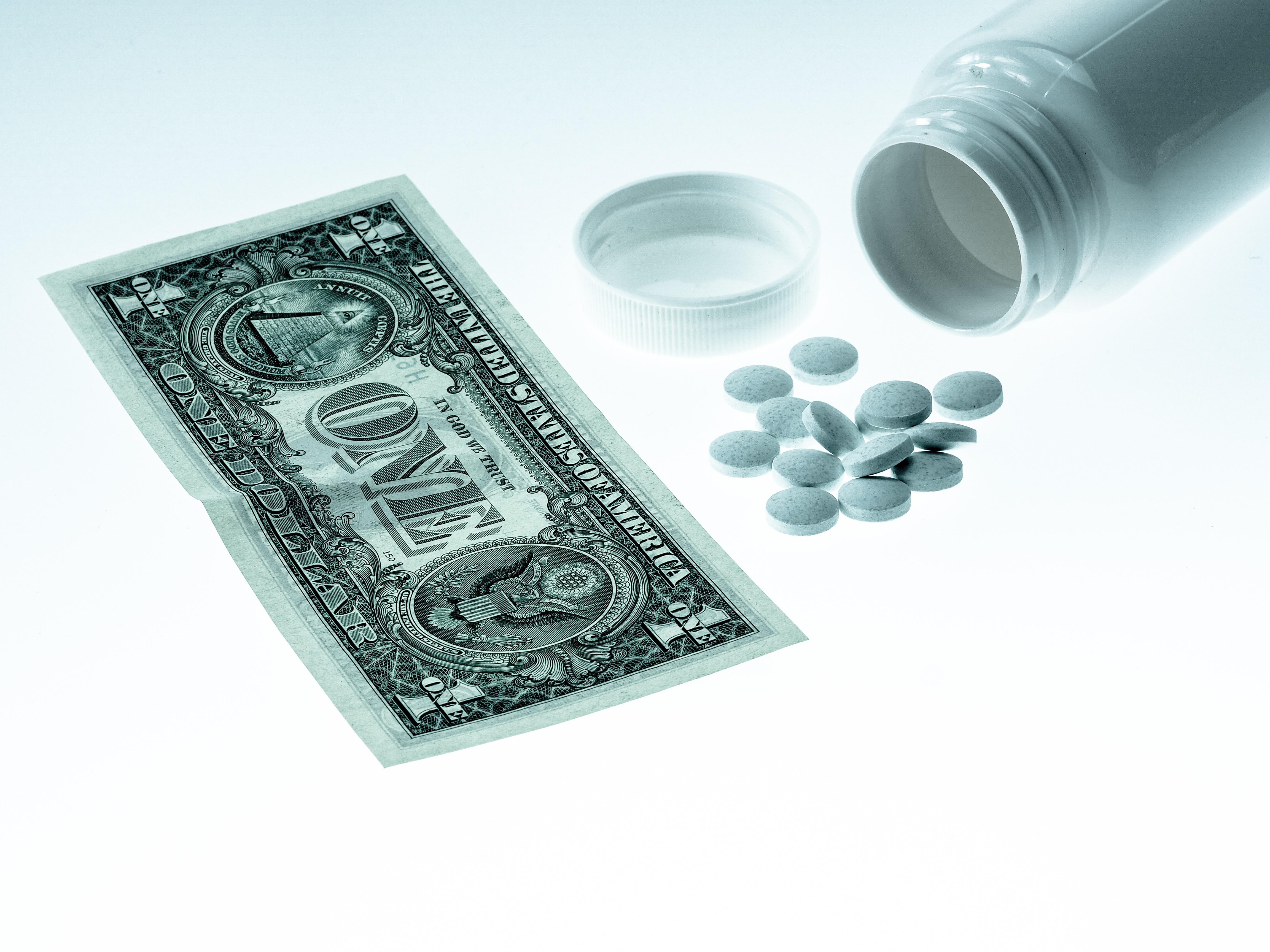 dollar bill with prescription bottle of medicine