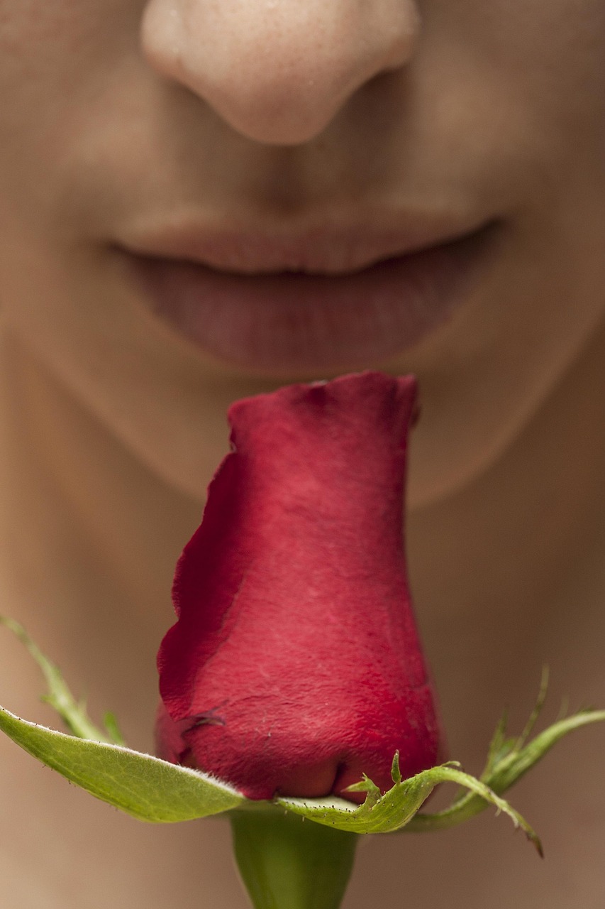 person smelling a rosebud