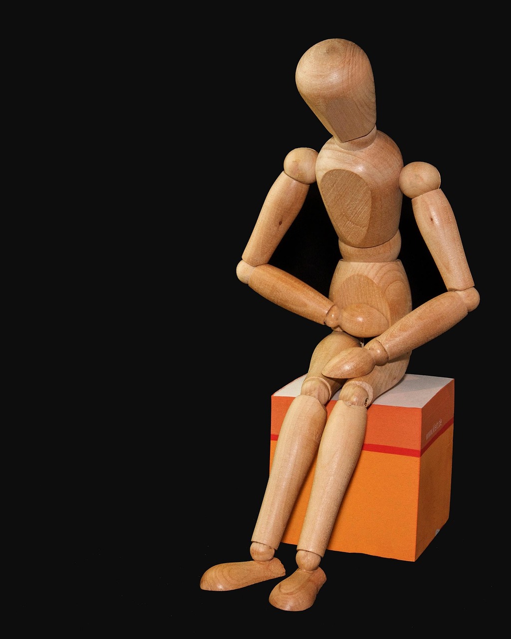 967 New way to treat pain Wooden jointed figure sitting hunched over in pain